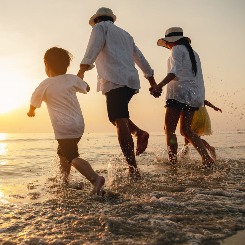 Happy asian family at consisting father, mother,son and daughter having fun playing beach in summer vacation on the beach.Happy family and vacations concept.